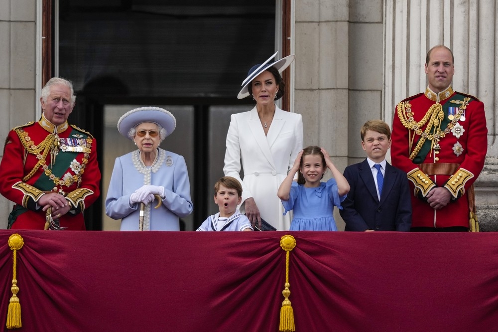 王室成員在白金漢宮陽台觀禮時，女王身旁的路易、夏綠蒂、喬治格外搶鏡。（美聯社）