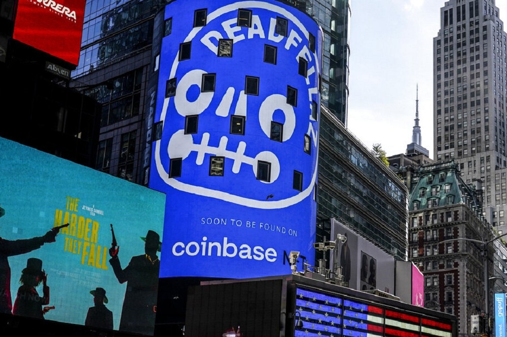 加密貨幣交易所Coinbase 14日宣佈將裁員18％。圖為該公司在紐約時報廣場的廣告。（美聯社）