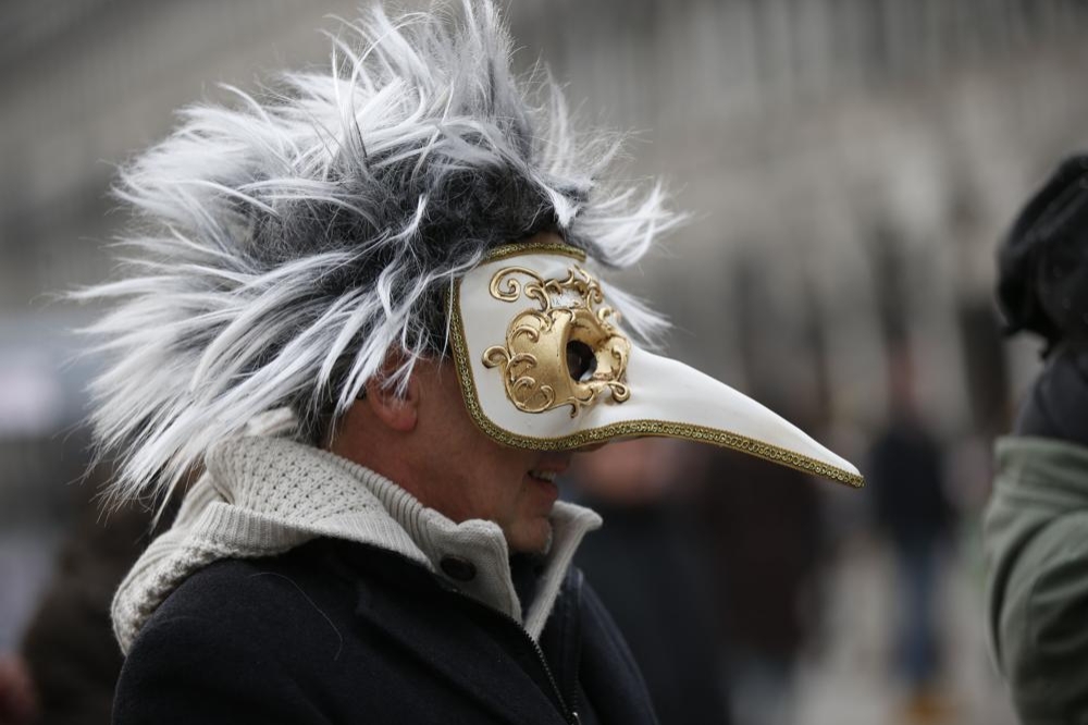 威尼斯佳年華民眾戴上中古世紀醫生預防感染用的喙鼻面具。（美聯社）