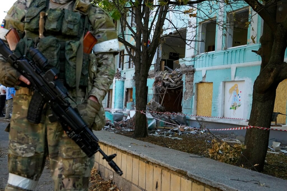 俄軍站在頓涅茨克被炸毀的學校旁（美聯社）