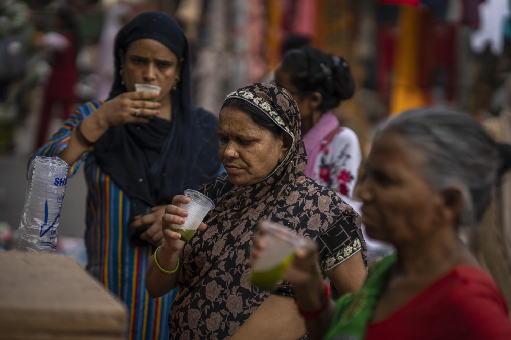 印度民眾在街邊用塑膠杯喝果汁（美聯社）