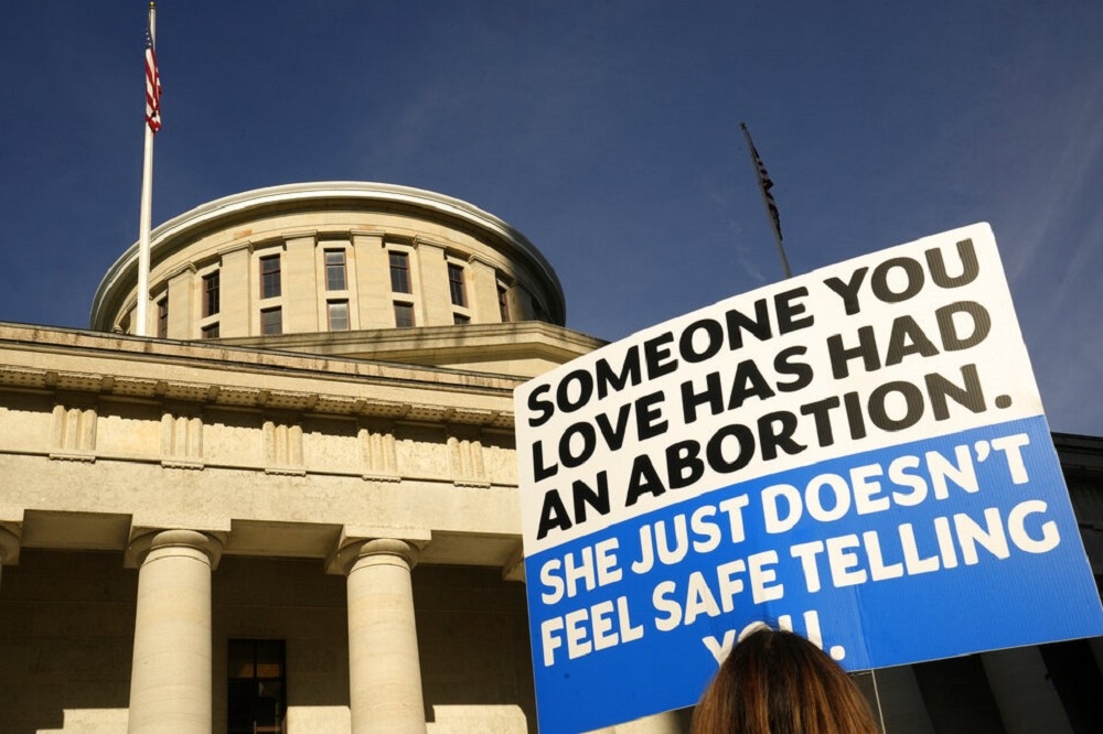 俄亥俄州議會大廈前支持墮胎人士手舉標語：「一個你愛的人曾去墮胎，她只是不放心告訴你」。（美聯社）