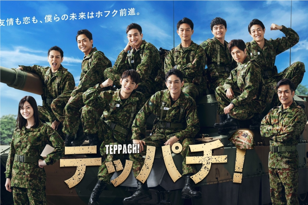 町田啓太（前排中）在《鋼盔！》中化身自衛隊成員，宣傳海報上他與演員們一起在坦克車前留影。（取自《鋼盔！》Twitter）