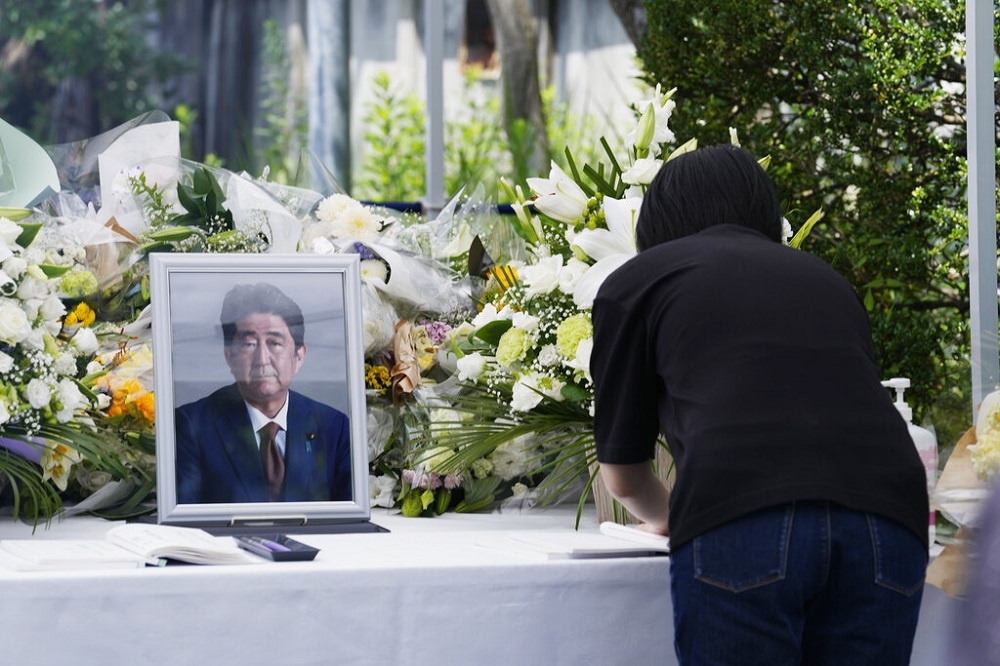 日本民眾在安倍晉三的靈前獻花，並留下哀悼訊息。（美聯社）