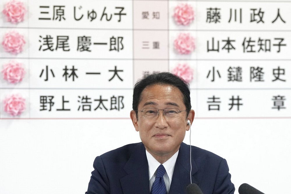 日本首相岸田文雄為當選的參議員貼上紅玫瑰標示。（美聯社）
