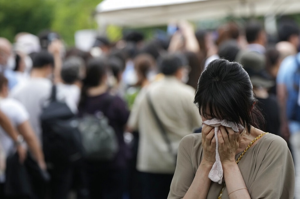 日本民眾在安倍晉三的葬禮外掩面哭泣。（美聯社）