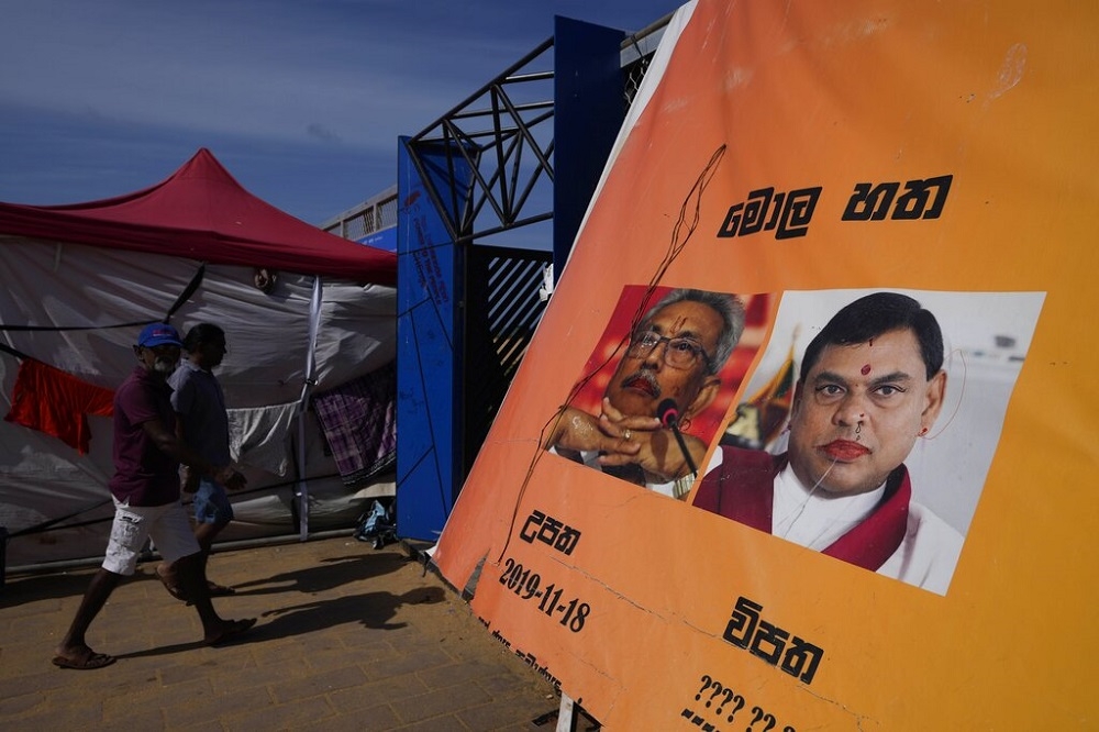 斯里蘭卡總統拉賈帕克薩和弟弟巴席爾的海報遭民眾塗鴉。（美聯社）