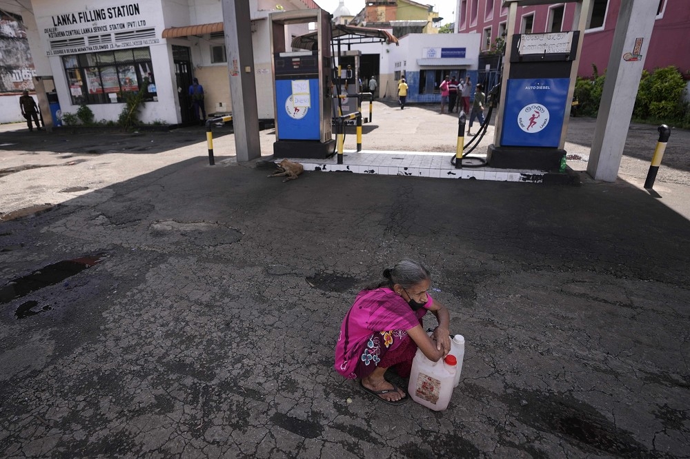 可倫坡一處加油站已無油可賣，老婦人仍心存一絲希望。（美聯社）