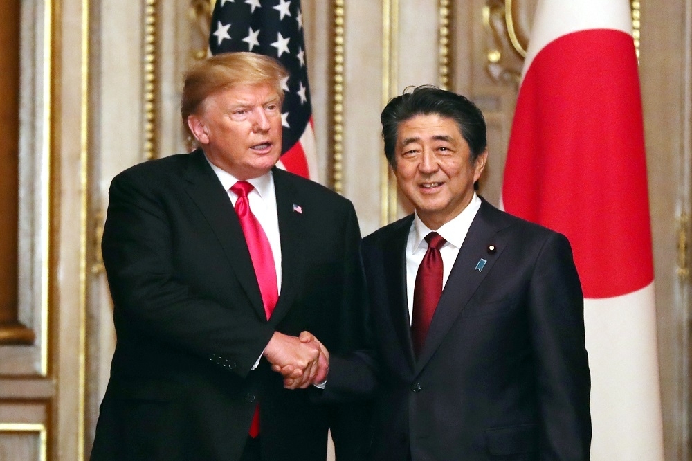 2019年，時任美國總統川普（左）前往日本會晤時任日本首相安倍晉三。（湯森路透）