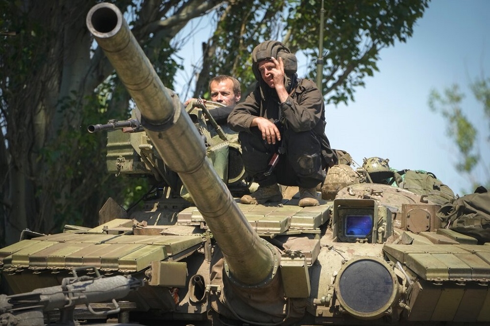 頓內茨克的烏克蘭軍人蹲在坦克上，比出勝利手勢。（資料照片／美聯社）