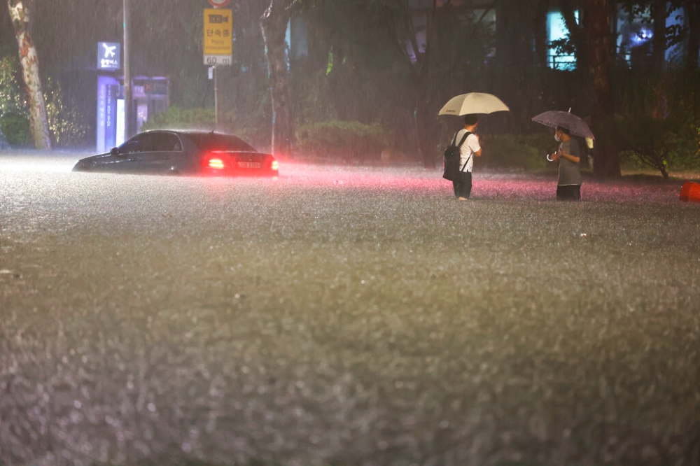 首爾8日遭遇暴雨襲擊，江南區街道頓時成了河流，不少車輛泡水（美聯社）