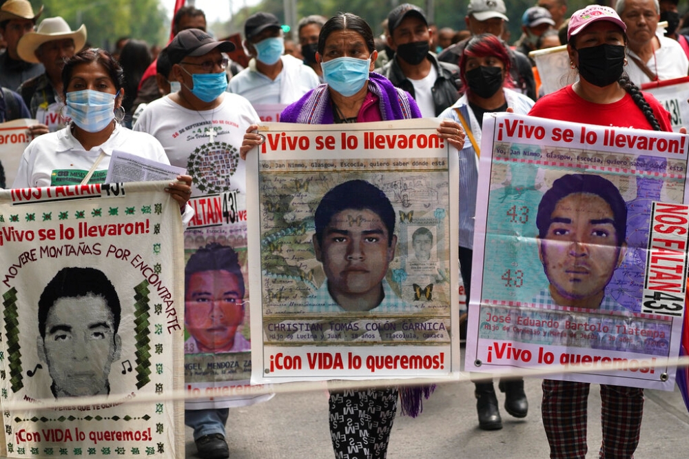 墨西哥43名失蹤學生家屬及聲援民眾26日冒雨在街頭遊行（美聯社）