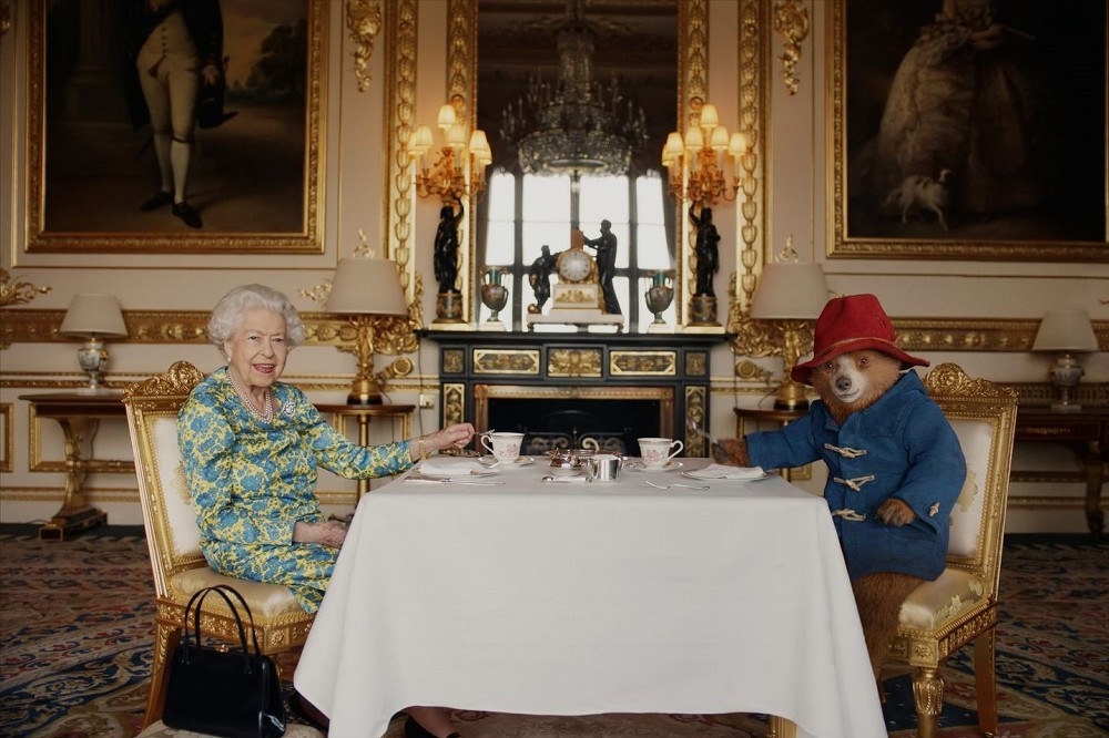 今年8月童書角色柏靈頓熊與女王共進下午茶，拍片慶祝女王登基70周年白金禧。（取自The Royal Family臉書）