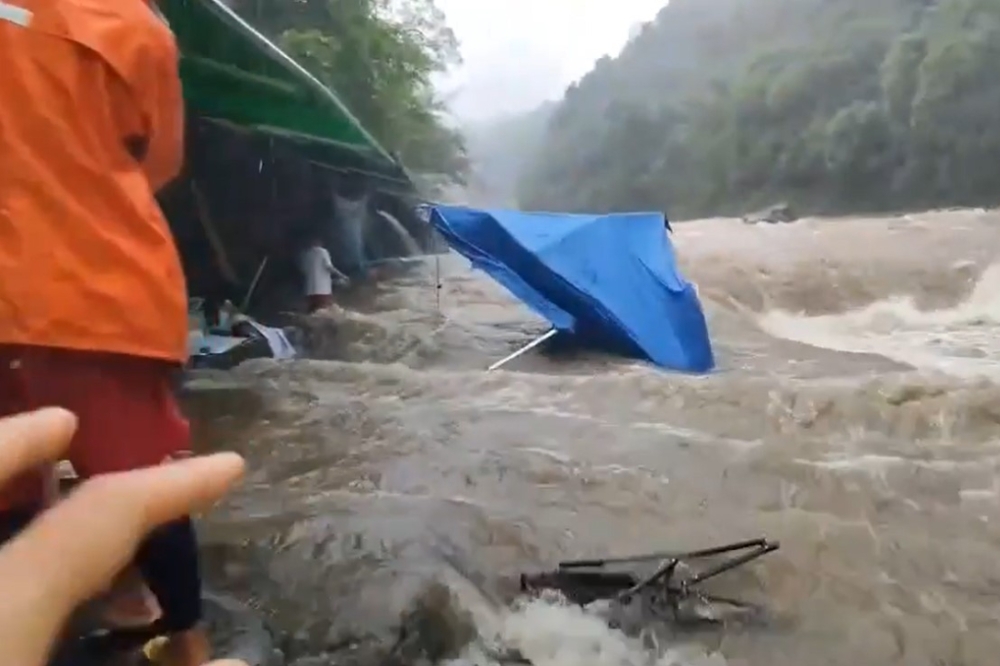 民眾颱風天到新北市大豹溪烤肉，結果遇溪水暴漲，急忙逃生，烤肉棚架及器具被沖走。（取自臉書爆料公社公開版）