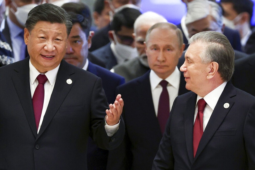 習近平（左）16日與俄國總統普丁（中）、烏茲別克總統米爾濟約耶夫（右）走進峰會會場。（美聯社）