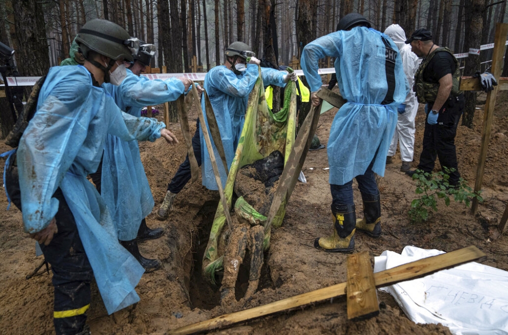 烏克蘭收復戰略城市伊久姆後，在當地松樹林發現埋有至少445具遺體的亂葬崗。（美聯社）