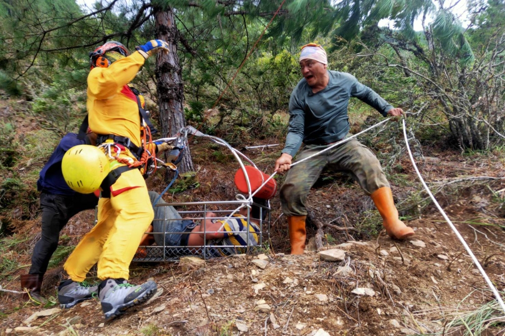 1名工人在武陵農場除草時遭蜂螫，經出動直升機將被蜂螫的40歲的松男吊掛上機，送醫急救後目前生命跡象穩定。（翻攝畫面）