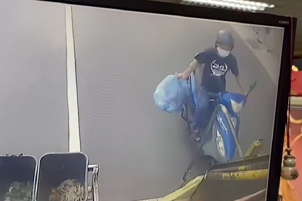 一名男子一手拿著垃圾袋一手騎車，追趕在垃圾車後面。（翻攝畫面）