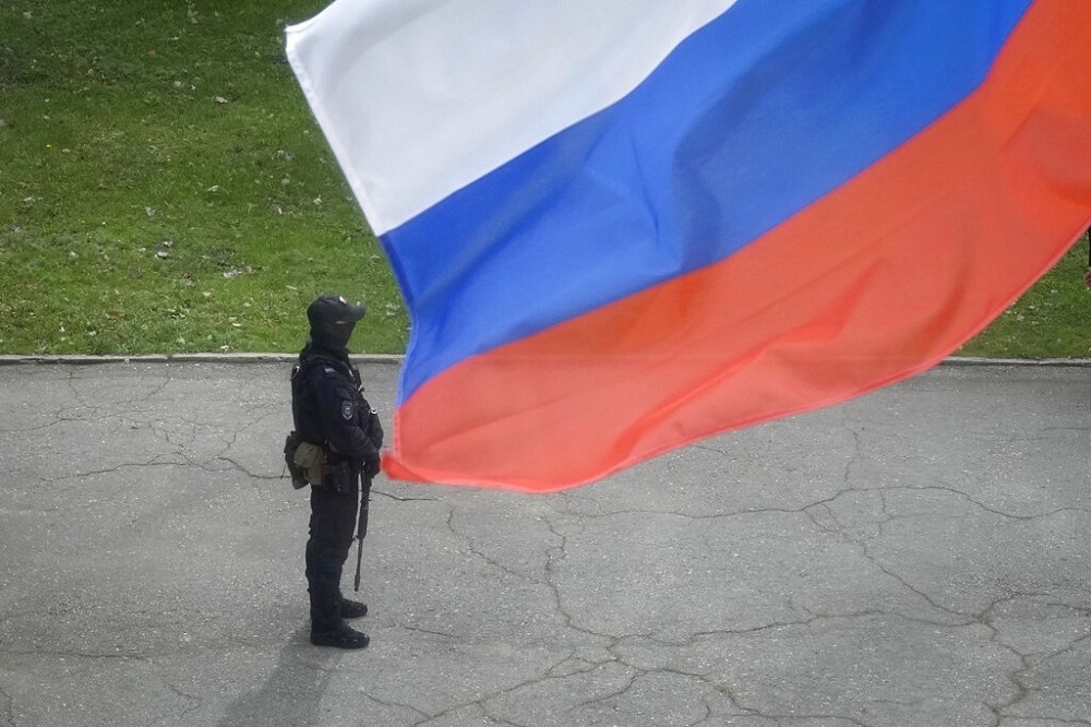 俄國在烏克蘭佔領區盧甘斯克舉辦入俄公投，投票所外有俄警看守。（美聯社）