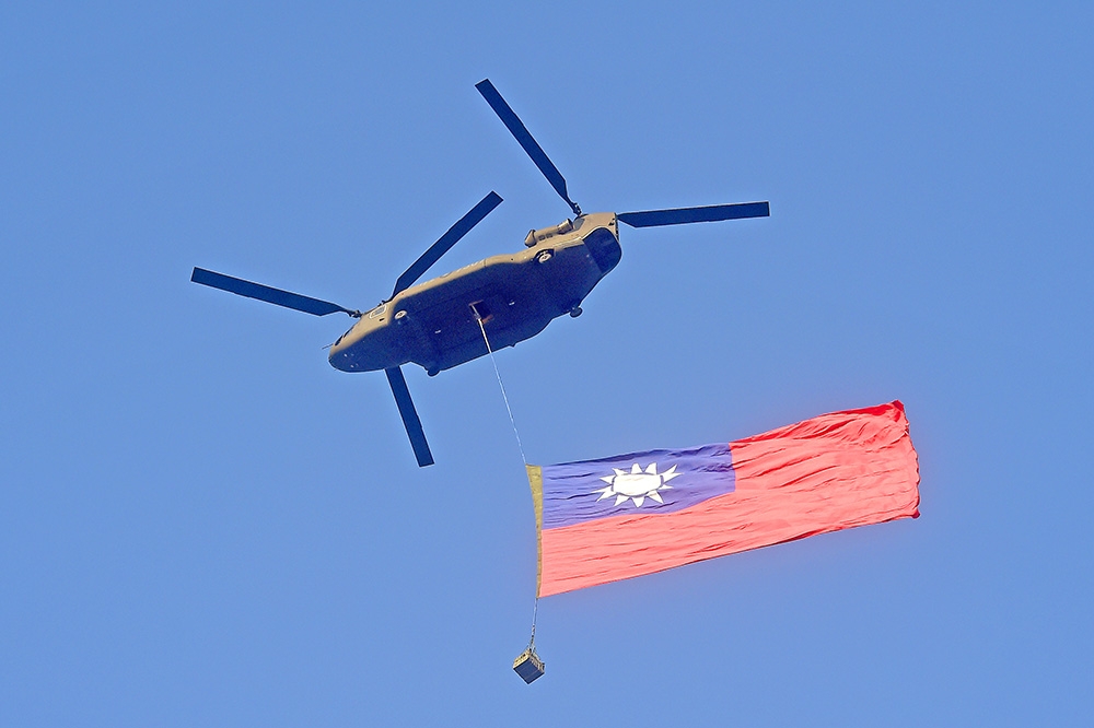 CH-47SD契努克直升機吊掛巨幅中華民國國旗飛越總統府上空，是此次操演的亮點。（張哲偉攝）