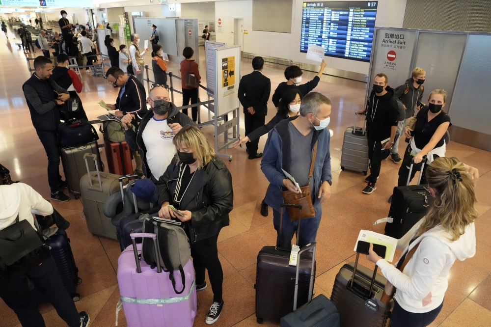 日本今起開放免簽自由行，羽田機場出現大批外國觀光客。（美聯社）