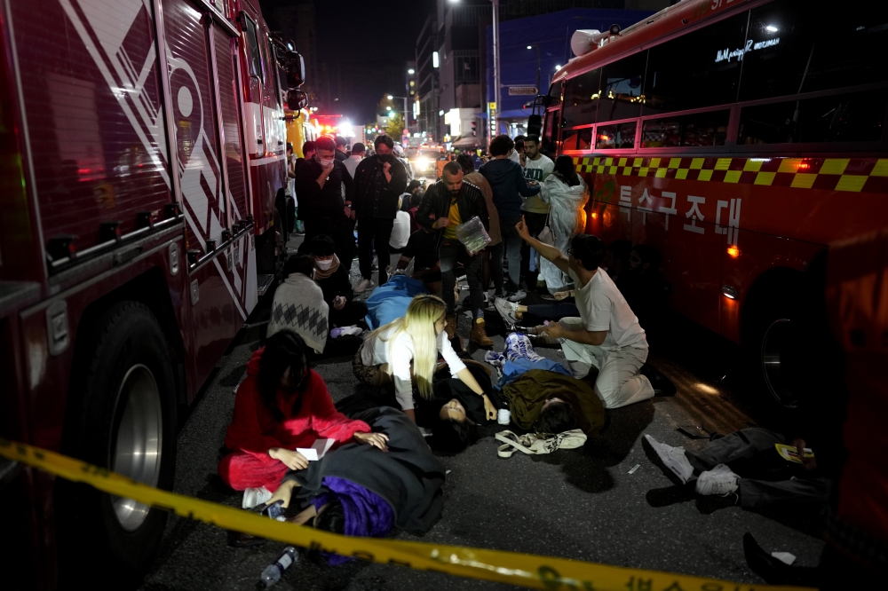 首爾救難人員30日凌晨在事故現場附近街道搶救傷患。（美聯社）