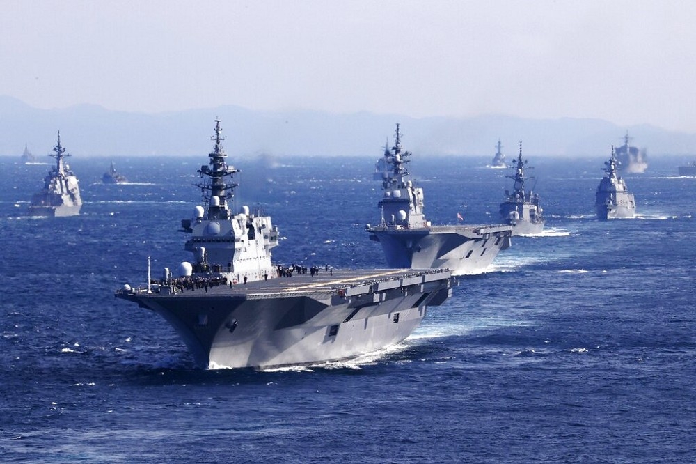 日本首相岸田文雄在「出雲號」護衛艦上，校閱參加的各國軍艦。（美聯社）