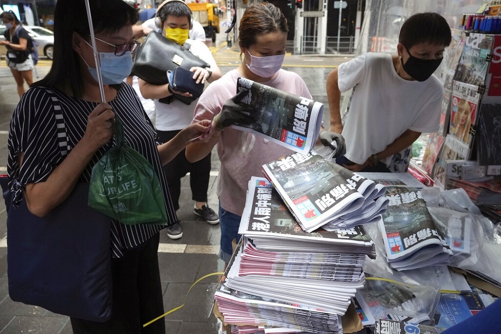 2021年6月24日，香港人在報攤排隊購買最後一期的蘋果日報。（資料照片／美聯社）