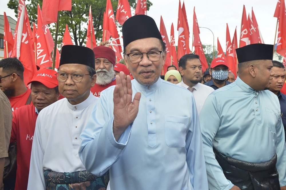 馬來西亞反對派領袖安華（中）被任命為首相，24日下午5時向國王宣誓後就職。（美聯社）