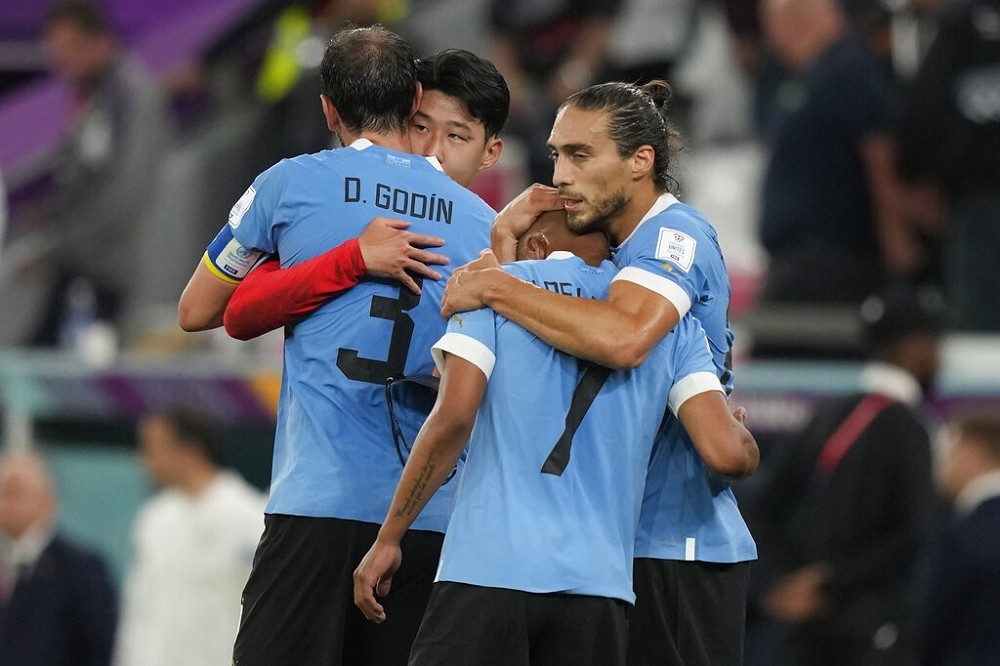 南韓隊與烏拉圭隊在和局後，南韓孫興慜與烏拉圭隊的戈丁（3號球衣）擁抱致意。（美聯社）