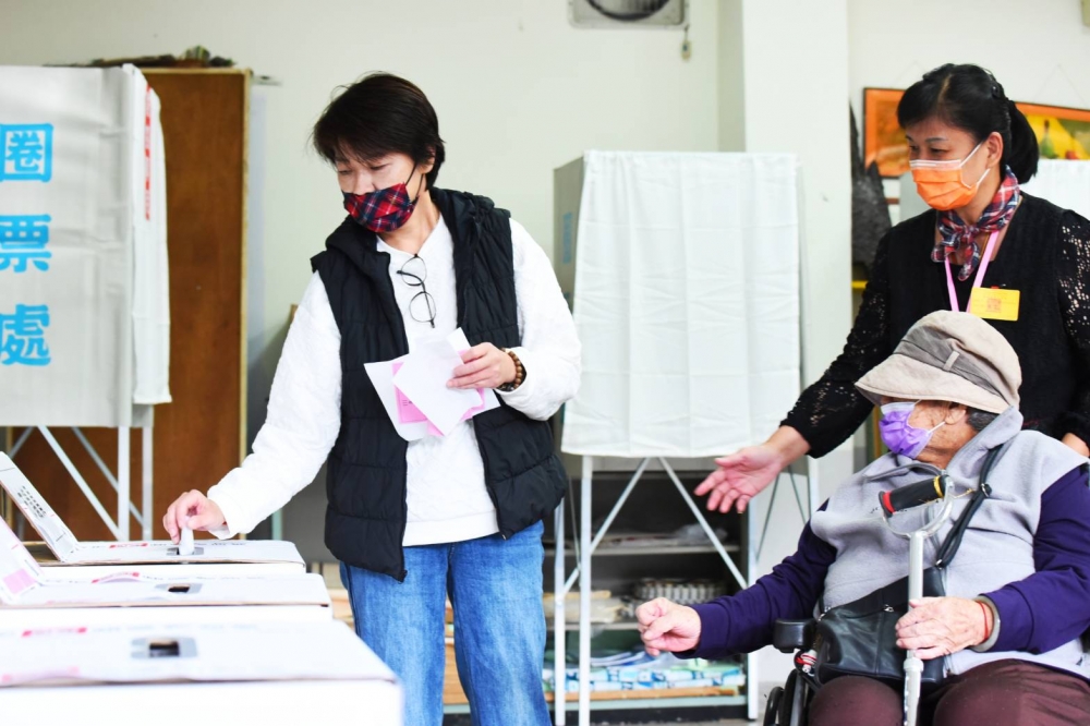 無黨籍台北市長候選人黃珊珊上午推著坐輪椅的93歲母親「老美」到方濟中學投票。（楊約翰攝）