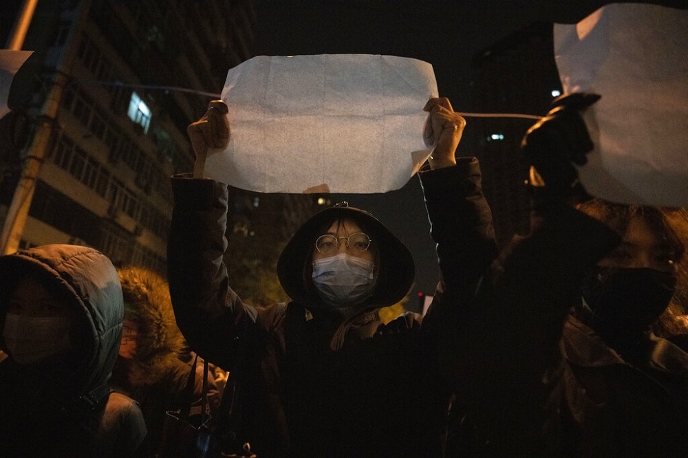 北京的抗爭者高舉一張白紙抗議。（美聯社）