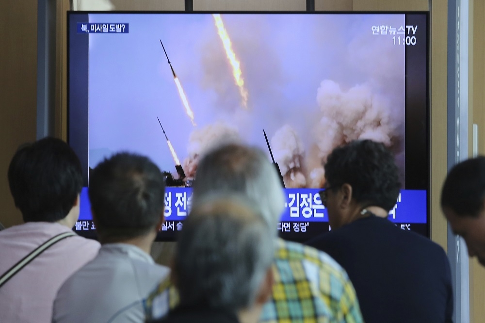 北韓5日向東、西部海域發射逾百發砲彈。圖為首爾民眾5月觀看相關新聞報導。（美聯社）