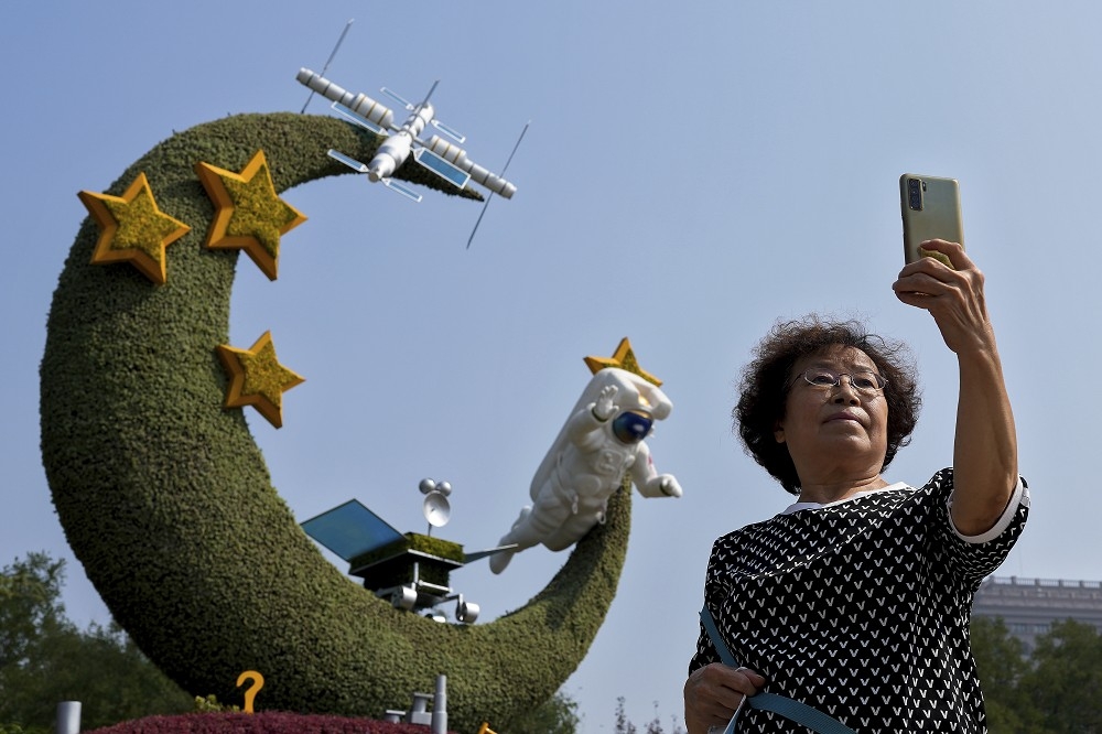 中国在太空领域急速发展，让美国备感威胁。图为2022年中国国庆时，北京妇女与中国航天项目的花卉装饰合影。（美联社）(photo:UpMedia)