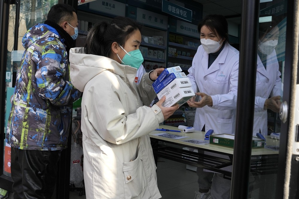 胡錫進發文批官方確診統計失準，圖為北京民眾排隊搶購防疫物資。（美聯社）