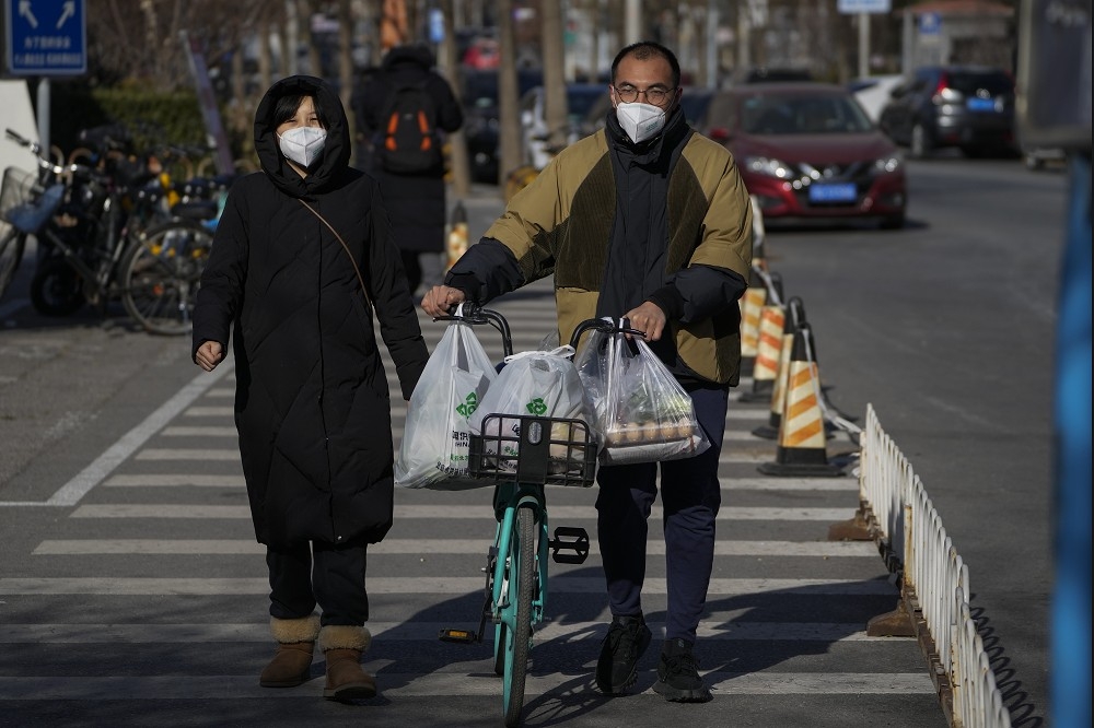 中國各地疫情升溫，有導致病毒變異的可能。圖為北京街頭民眾在解封後，外出購買民生用品。（美聯社）