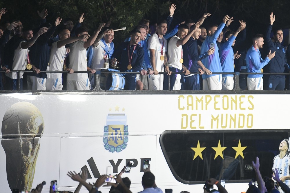 阿根廷國家隊20日凌晨歸國，站在大巴上向等候多時的球迷揮手致意。（美聯社）