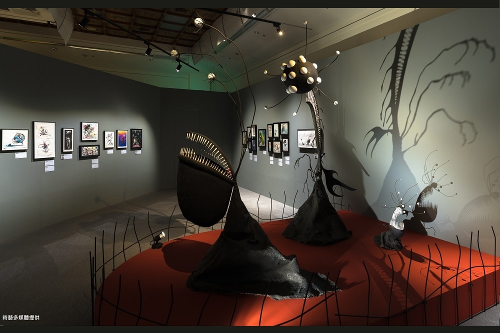 《提姆波頓異想世界展》第三展區展出各種看不清是人類或是怪獸的角色稿件，多媒體雕塑與投射燈搭配，營造出活潑但怪奇的氛圍。(時藝多媒體提供)