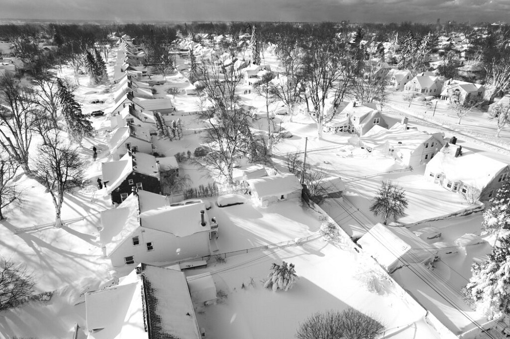 紐約州一處街區民宅被這場冬季風暴帶來的大雪完全覆蓋，數以百萬計的北美民眾被迫躲在家中避寒。（美聯社）