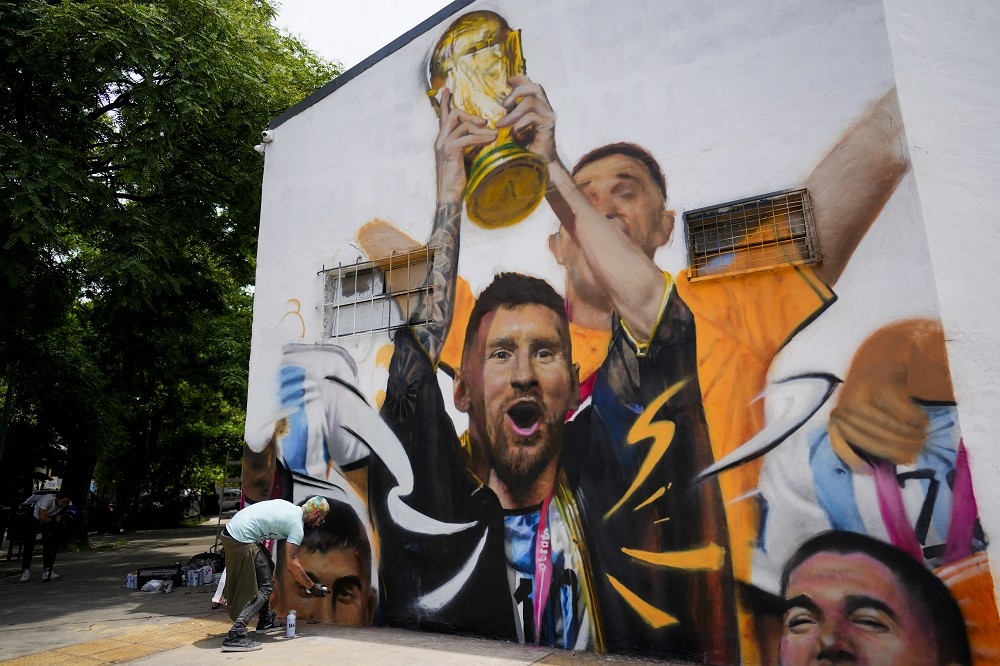 阿根廷街頭藝術，畫下梅西率領阿根廷捧起大力神杯的瞬間。（美聯社）