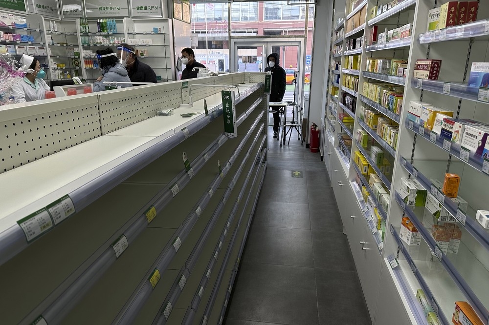 中國民眾搶購成藥的浪潮已擴散到日本等鄰近國家，圖為北京一間藥局，貨架已被搶空的情形。（美聯社）