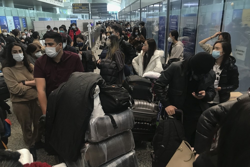 中國廣州白雲機場內的旅客，正在等候公車前往檢疫酒店。（美聯社）