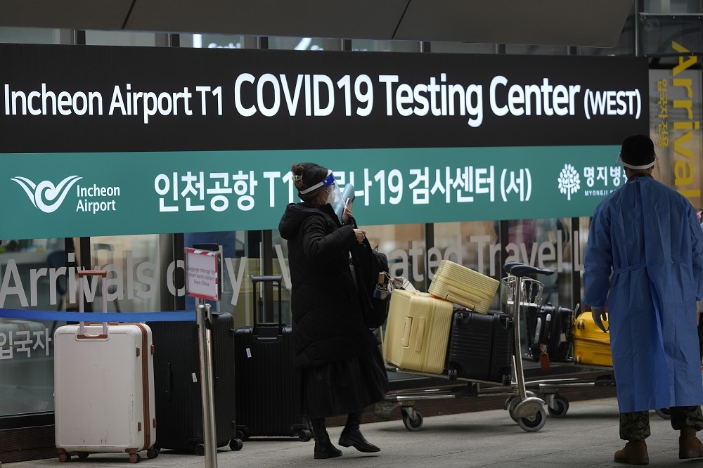 中國旅客正在仁川機場的新冠檢測中心排隊受檢。（美聯社）