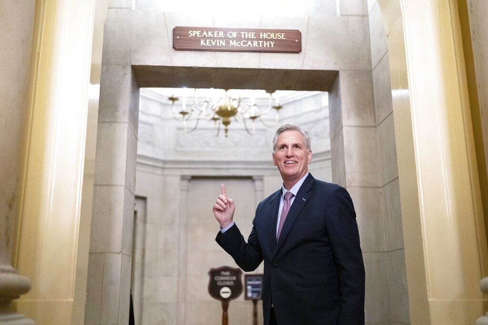 眾院共和黨領袖麥卡錫的辦公室外掛上了「議長」牌子，麥卡錫站在辦公室前笑容滿面。（美聯社）