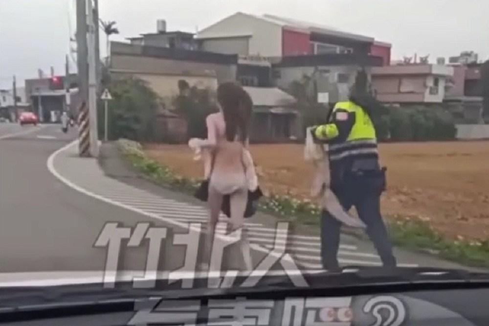 新竹一名妙龄女子在马路边裸奔，一名警察在后追赶要帮穿外套。（撷取自竹北人有事吗脸书社团）(photo:UpMedia)