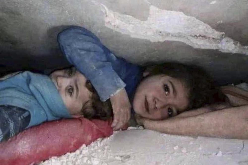 在敘利亞災區，受困的7歲女孩及其弟弟向救援人員求救。（取自@mhdksafa推特）
