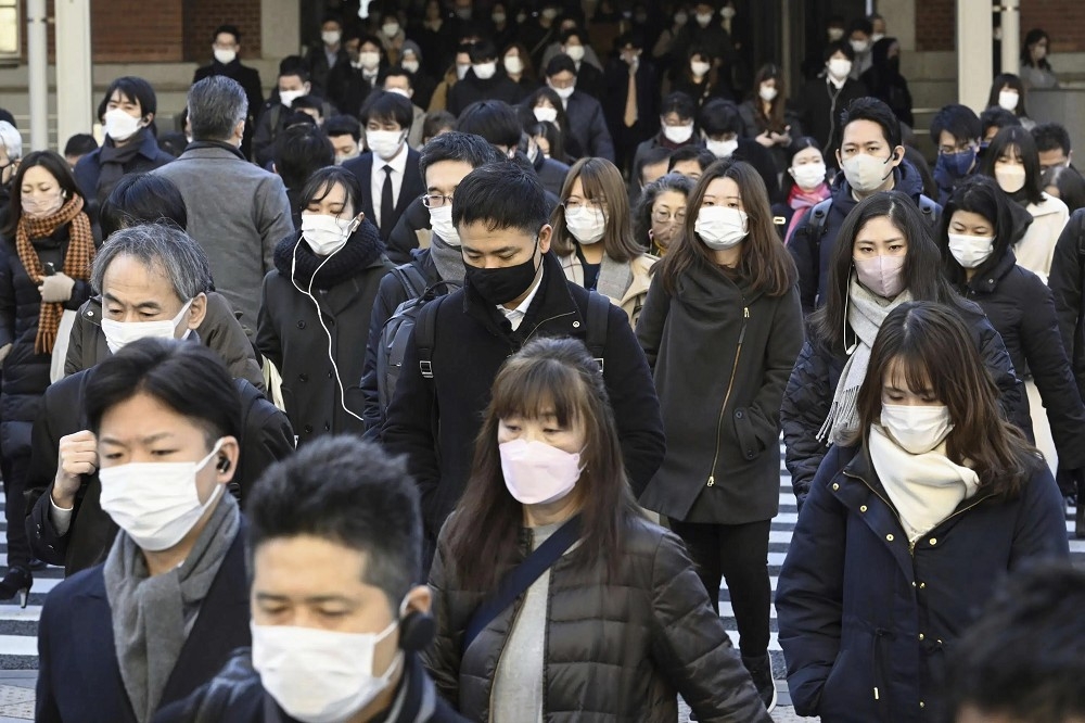 日本政府正式宣布從3月13日起，配戴口罩時機與地點將由民眾自行判斷，全面鬆綁防疫規定。（美聯社）