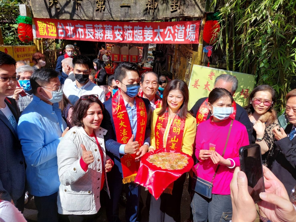 台北市長蔣萬安（中，藍色口罩）今天赴陽明山還願，並發送魚幣錢母給民眾。（翻攝畫面）
