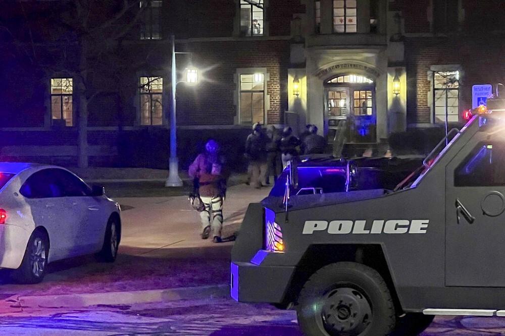 密西根州立大學槍擊案發生後，當地警方攜帶步槍等裝備對校內大樓逐一進行安全排查。（美聯社）