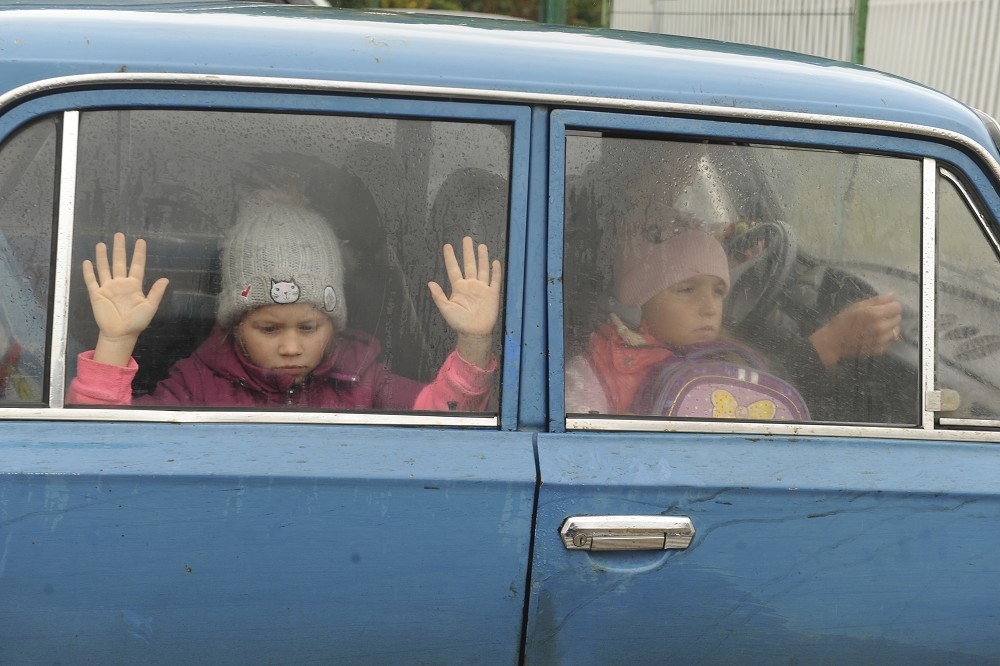 最新調查顯示，至少有6000名烏克蘭孩童被送入俄國再教育營。圖為烏克蘭家庭駕車逃離戰火的情形。（美聯社）